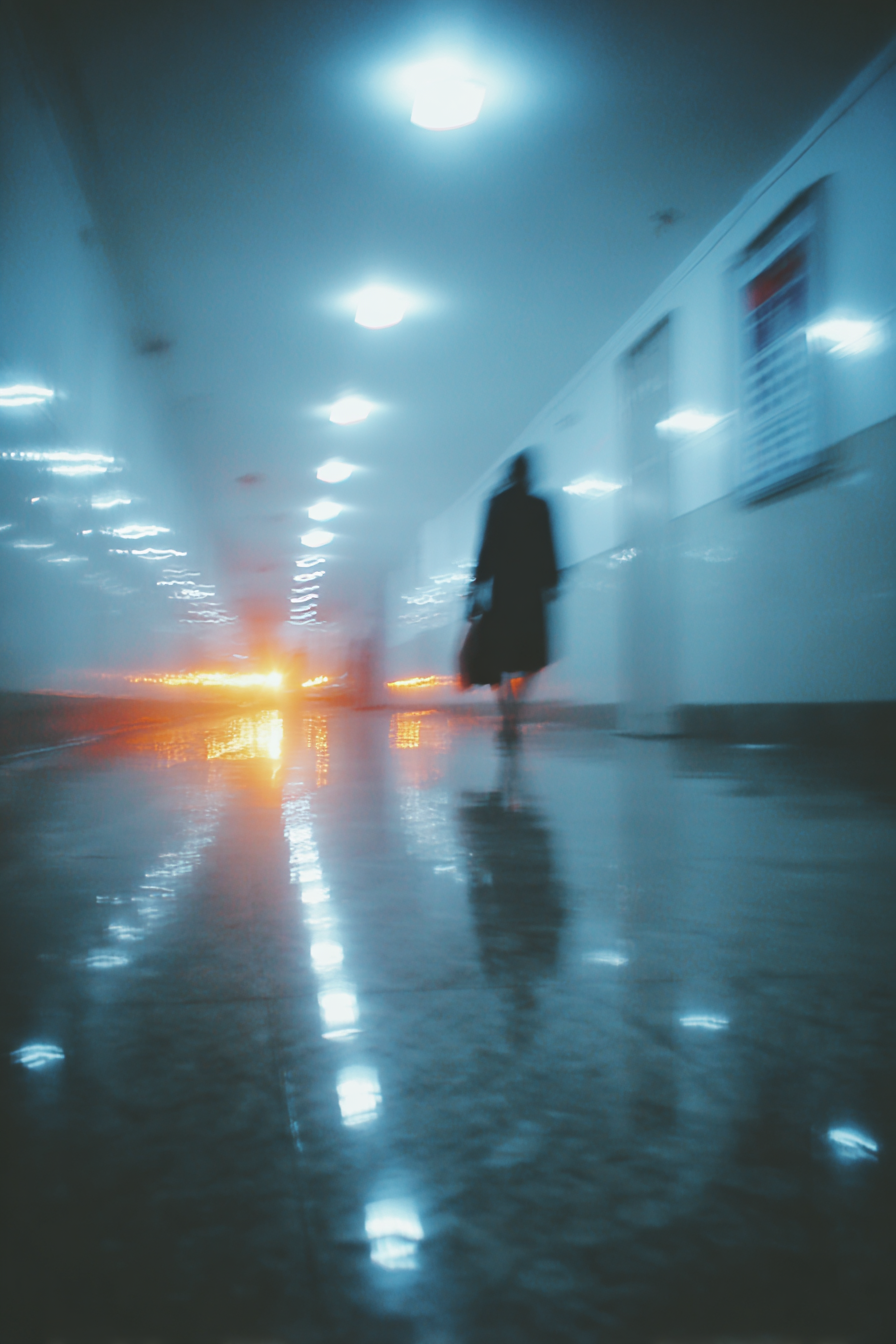 Figure Fading Down a Hospital Corridor