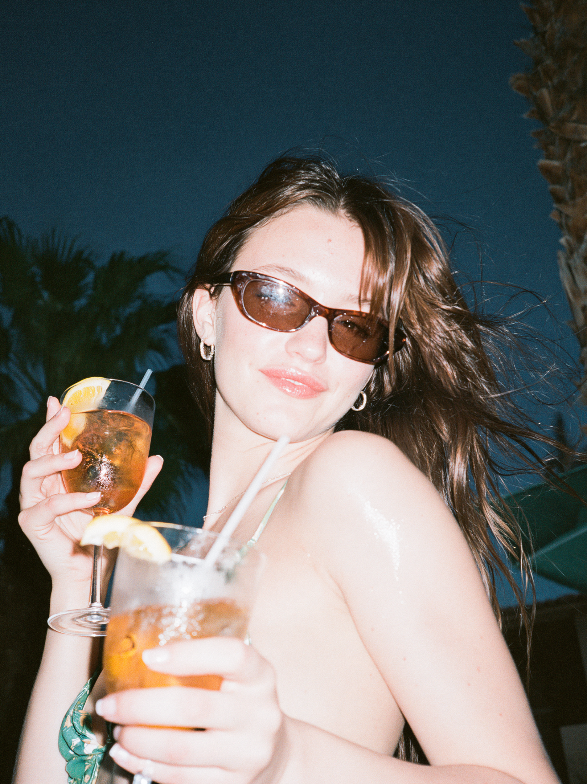 Frau mit Orangenspritz unter blauem Himmel